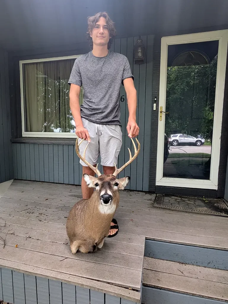 teenager holding deer head