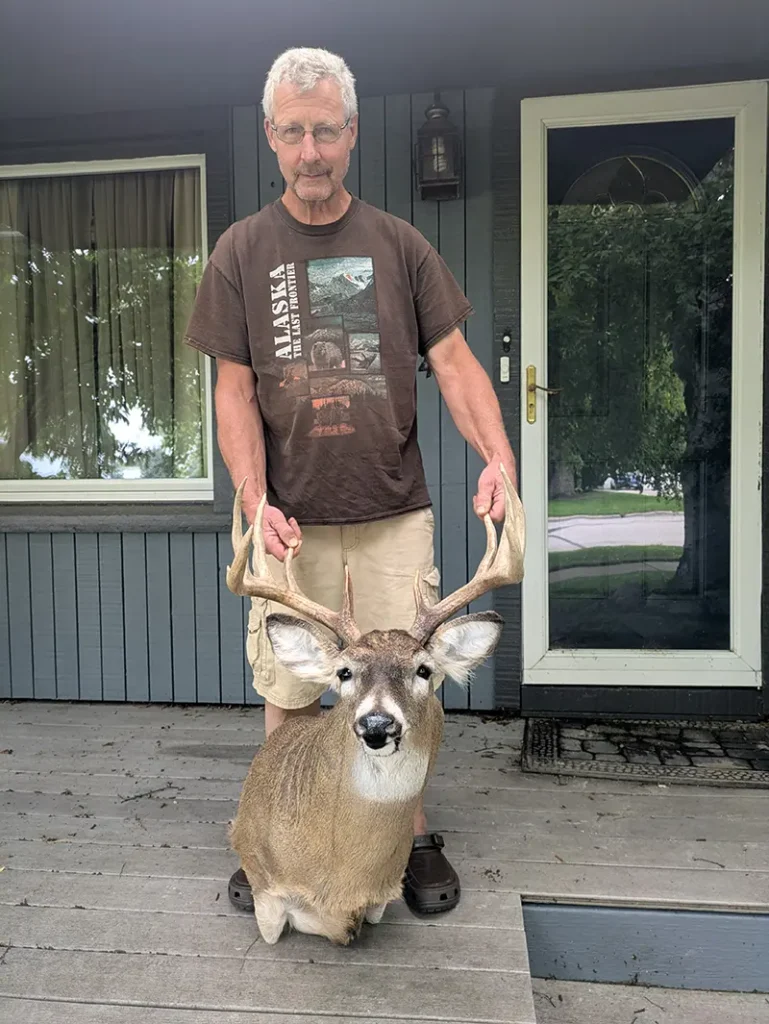man holding antlers on deer head